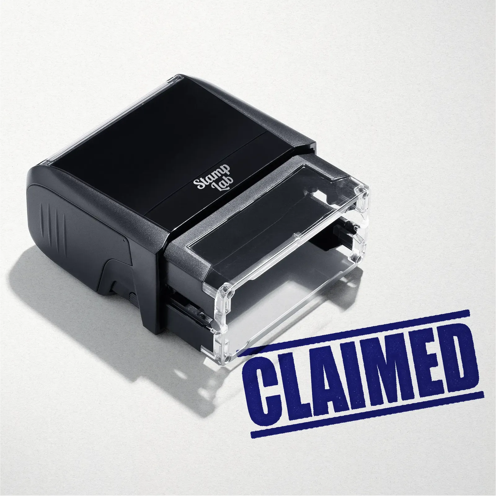 mock up design or lifestyle image of 'Claimed' rubber stamp blue ink in paper background stampers hand stamp office business inventory documents self inking prefill refillable stamps stamping
