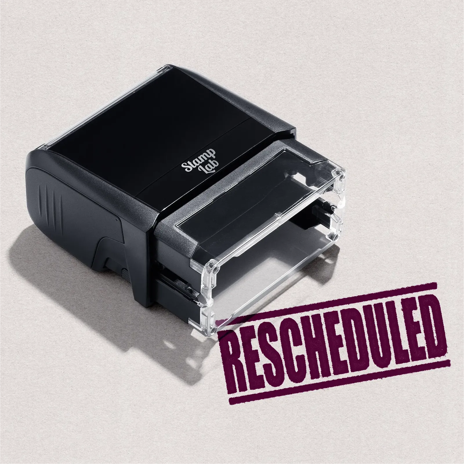 Black self-inking stamp with 'RESCHEDULED' text in Maroon ink
