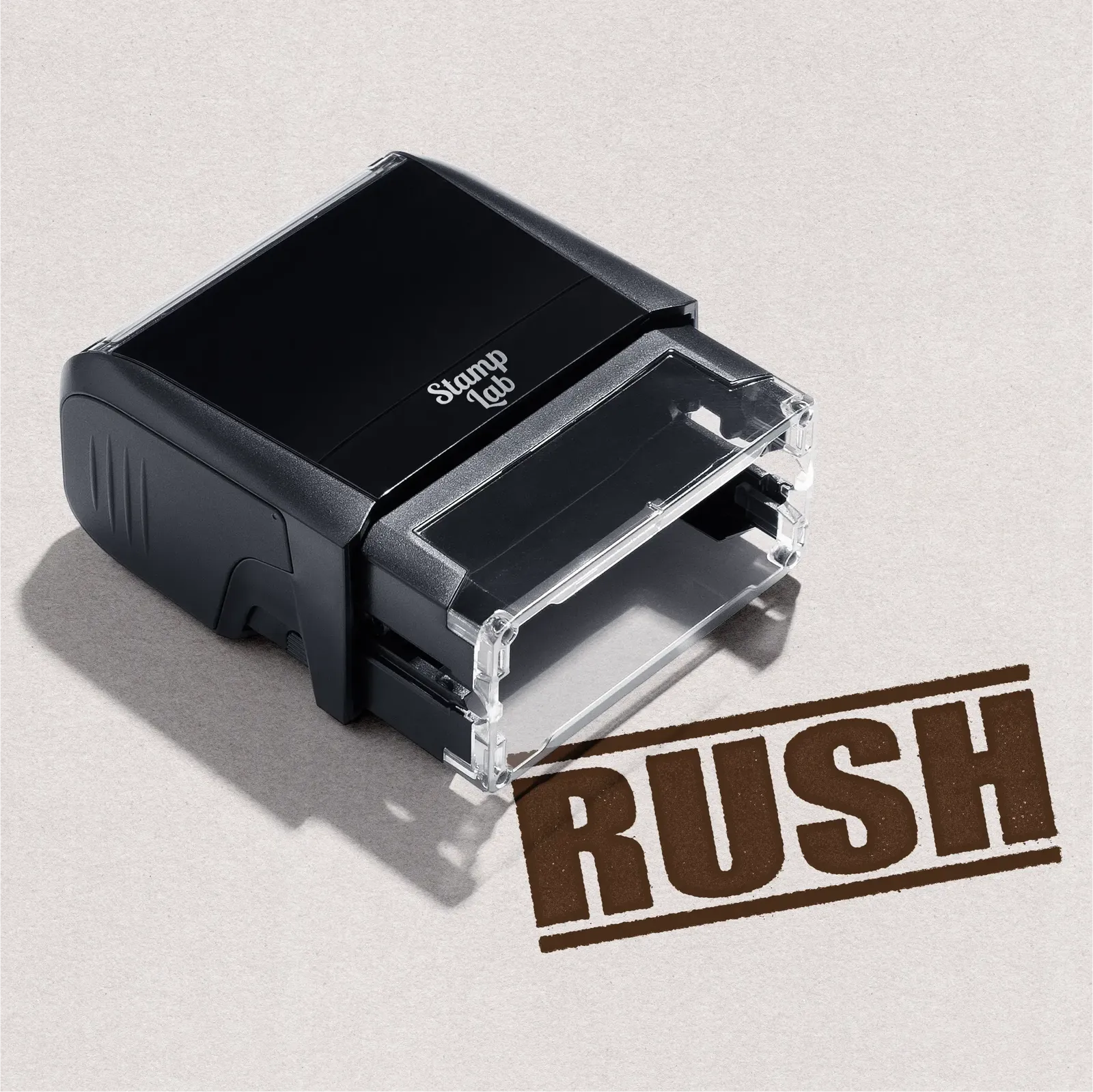 Black self-inking stamp with 'RUSH' impression in Brown ink on a light gray background